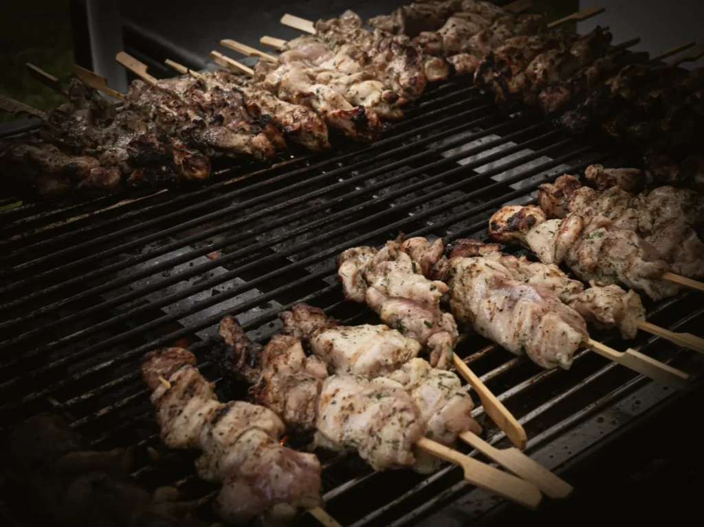 Kipspiesen op een gloeiende grill in de schemering