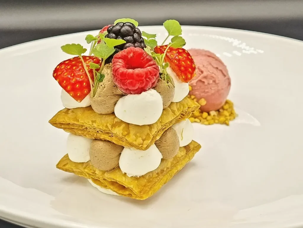 Millefeuille met room, aardbei, framboos en braam, met een bol ijs