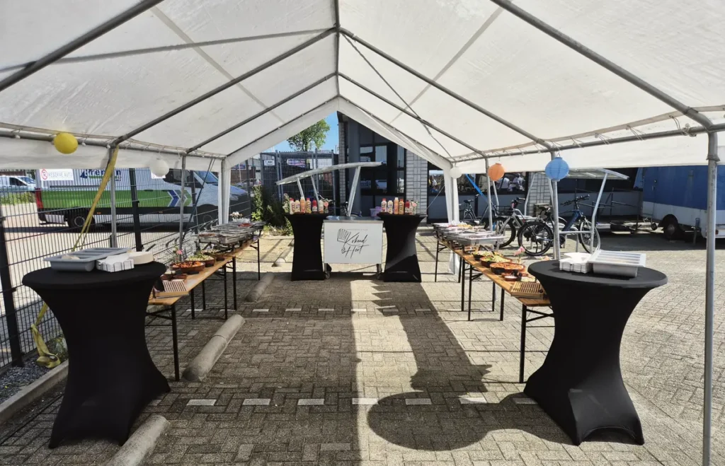 Een tent met statafels, klaar voor de gasten.